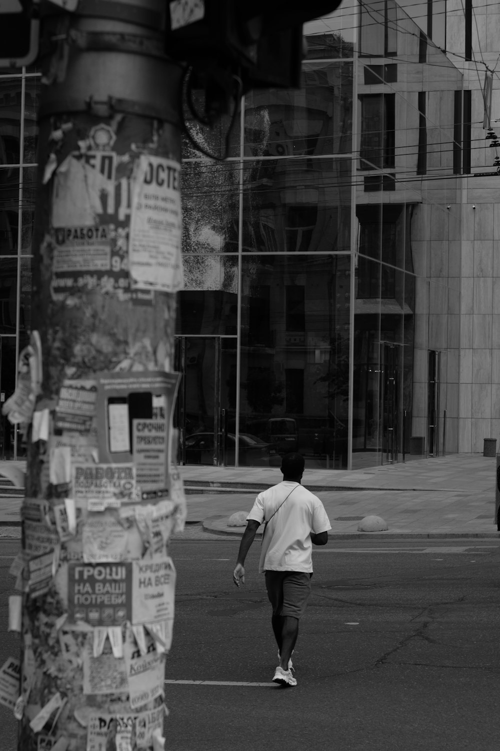 a man walking across a street next to a traffic light