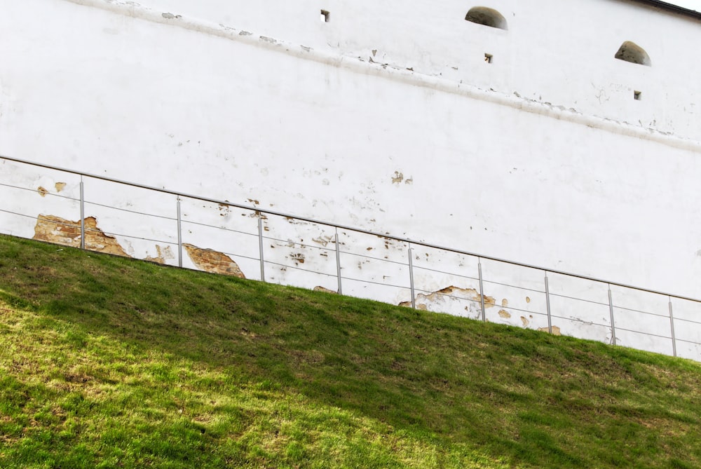 a large white building sitting on top of a lush green hillside