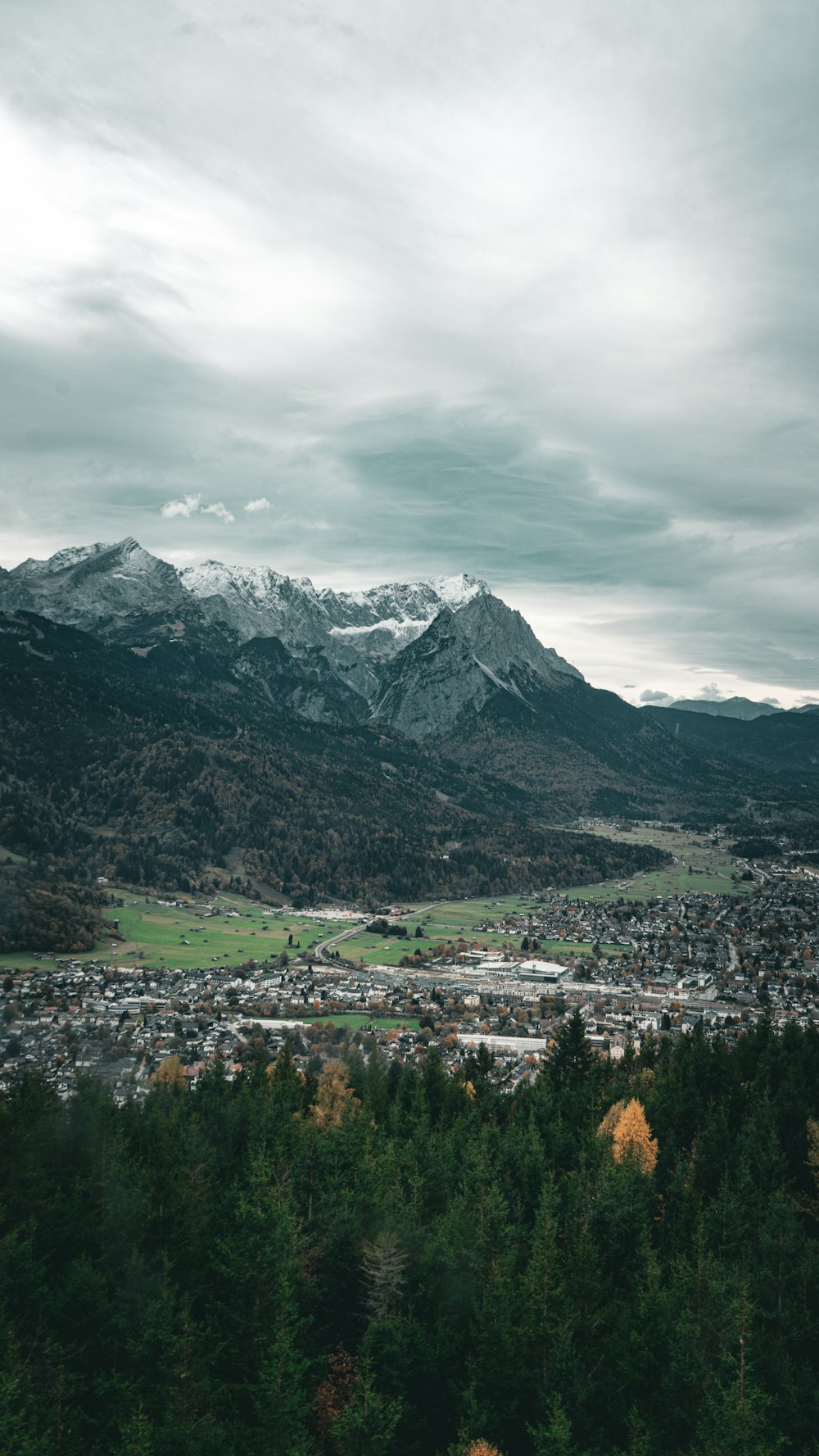 a scenic view of a city with mountains in the background