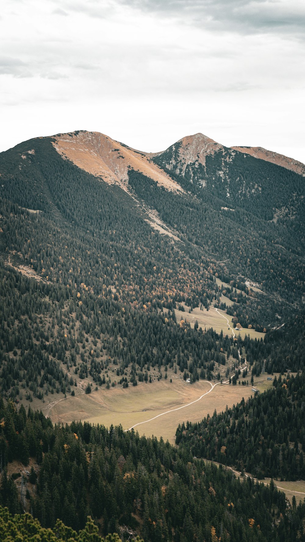 a scenic view of a mountain range with a valley in the foreground