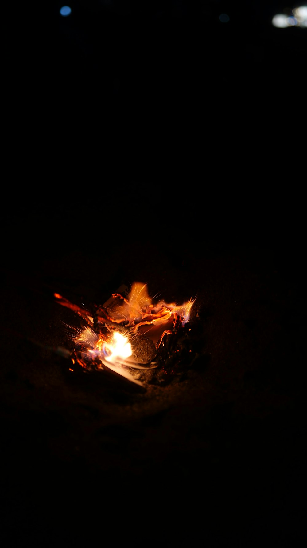 a lit fire in the dark with a black background