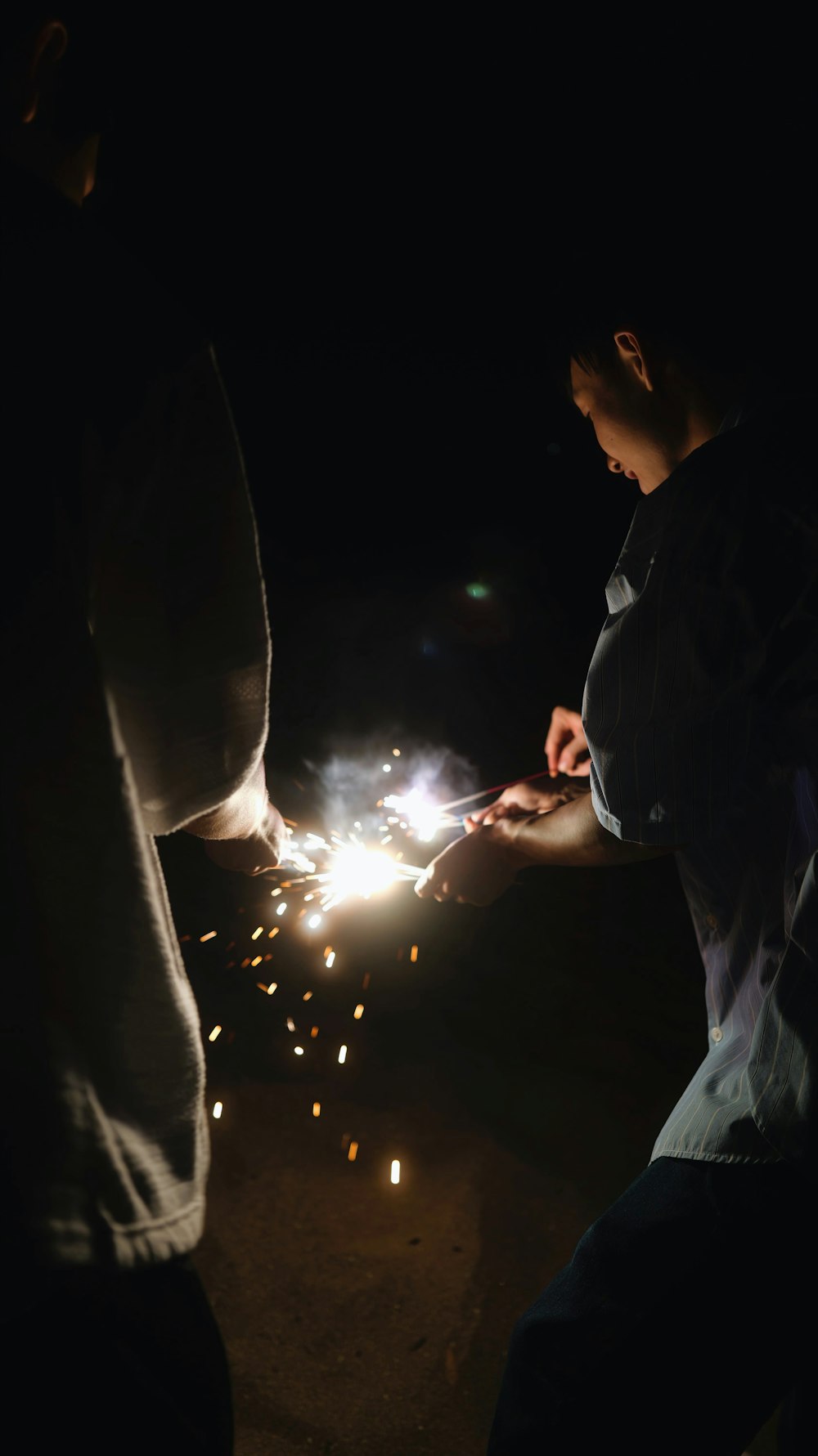 a couple of men standing next to each other holding sparklers