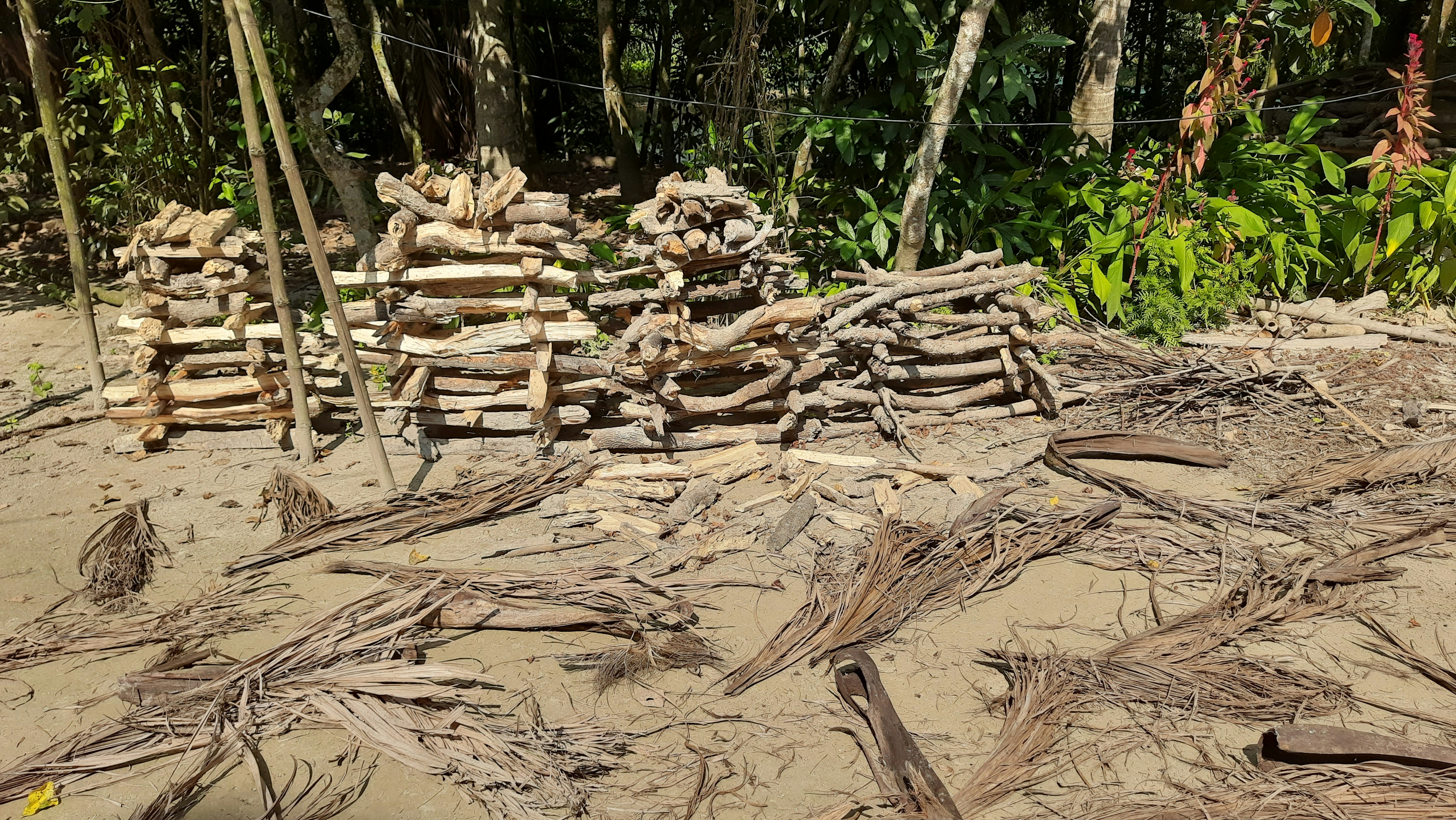 a pile of wood sitting on top of a sandy beach