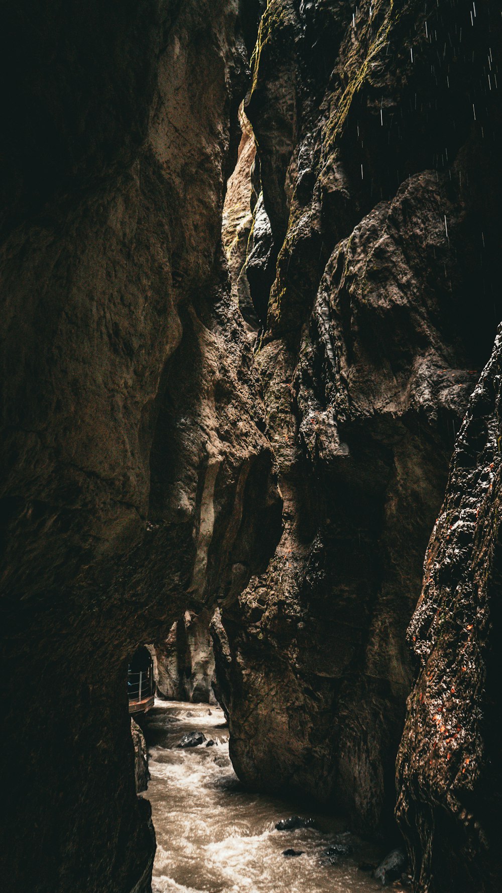 a person walking down a narrow path in a cave