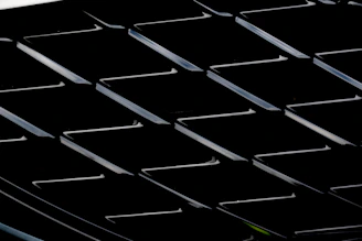 Close-up of a designer’s hand adjusting precise grid lines on a digital interface with dark luxury colors.