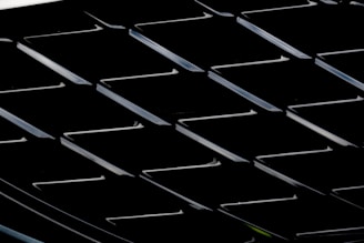 A sleek steel and gold industrial grid pattern glowing subtly against a charcoal background.