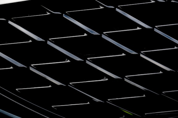 A sleek steel and gold industrial grid pattern glowing subtly against a charcoal background.