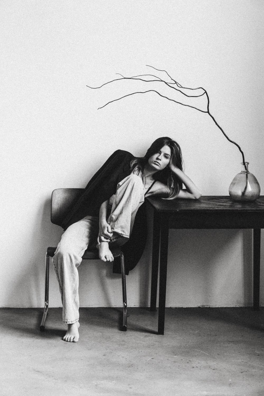 a black and white photo of a woman sitting on a chair