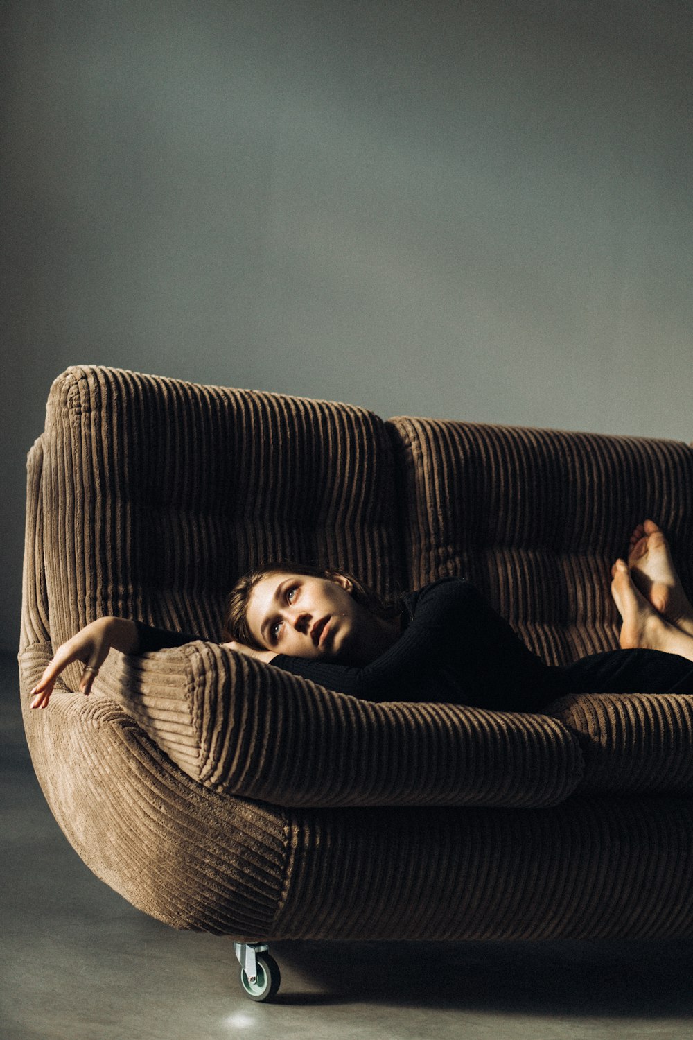 a woman is laying on a couch with wheels