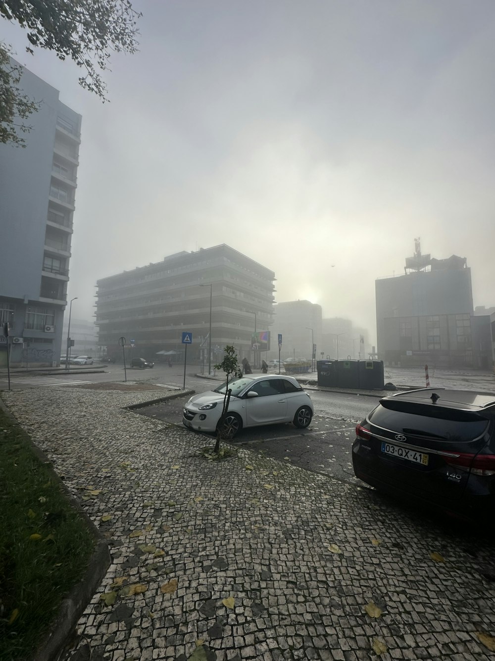 two cars are parked on a cobblestone street