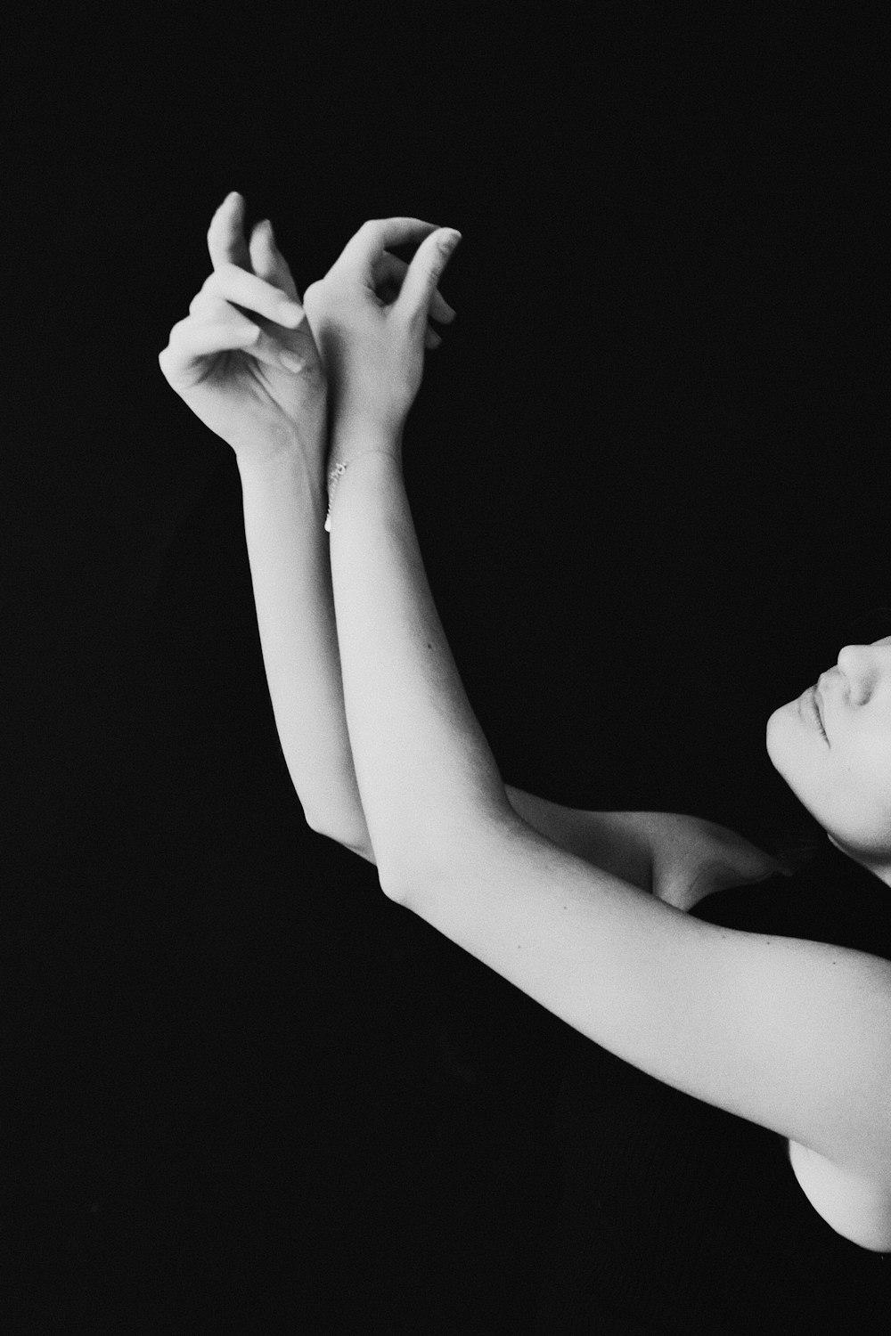 a black and white photo of a woman with her arm outstretched