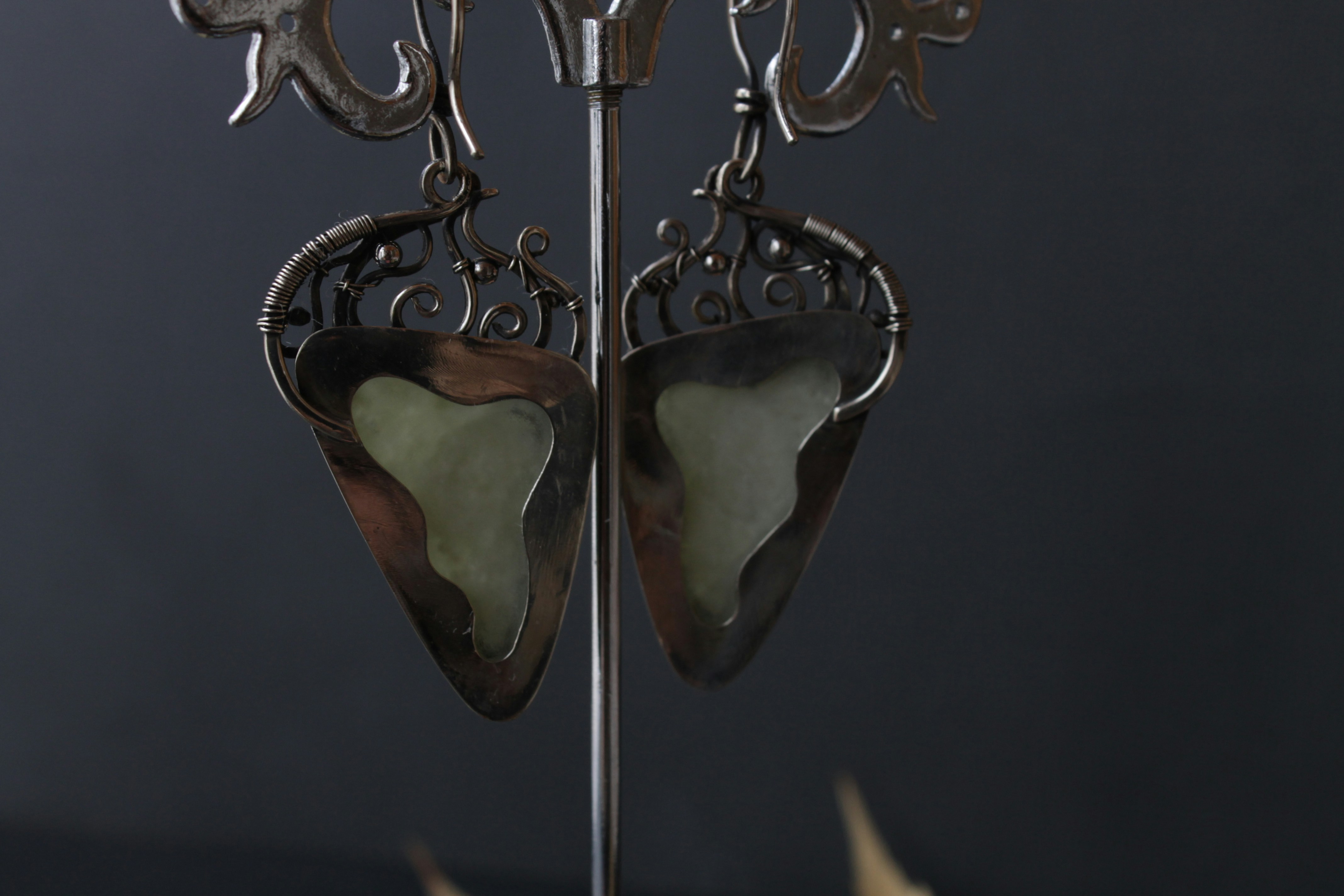 Gold teardrop earrings hanging on bright display in clean studio photography