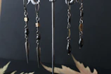 Earrings shaped like miniature gothic spires, catching light with their detailed metalwork.