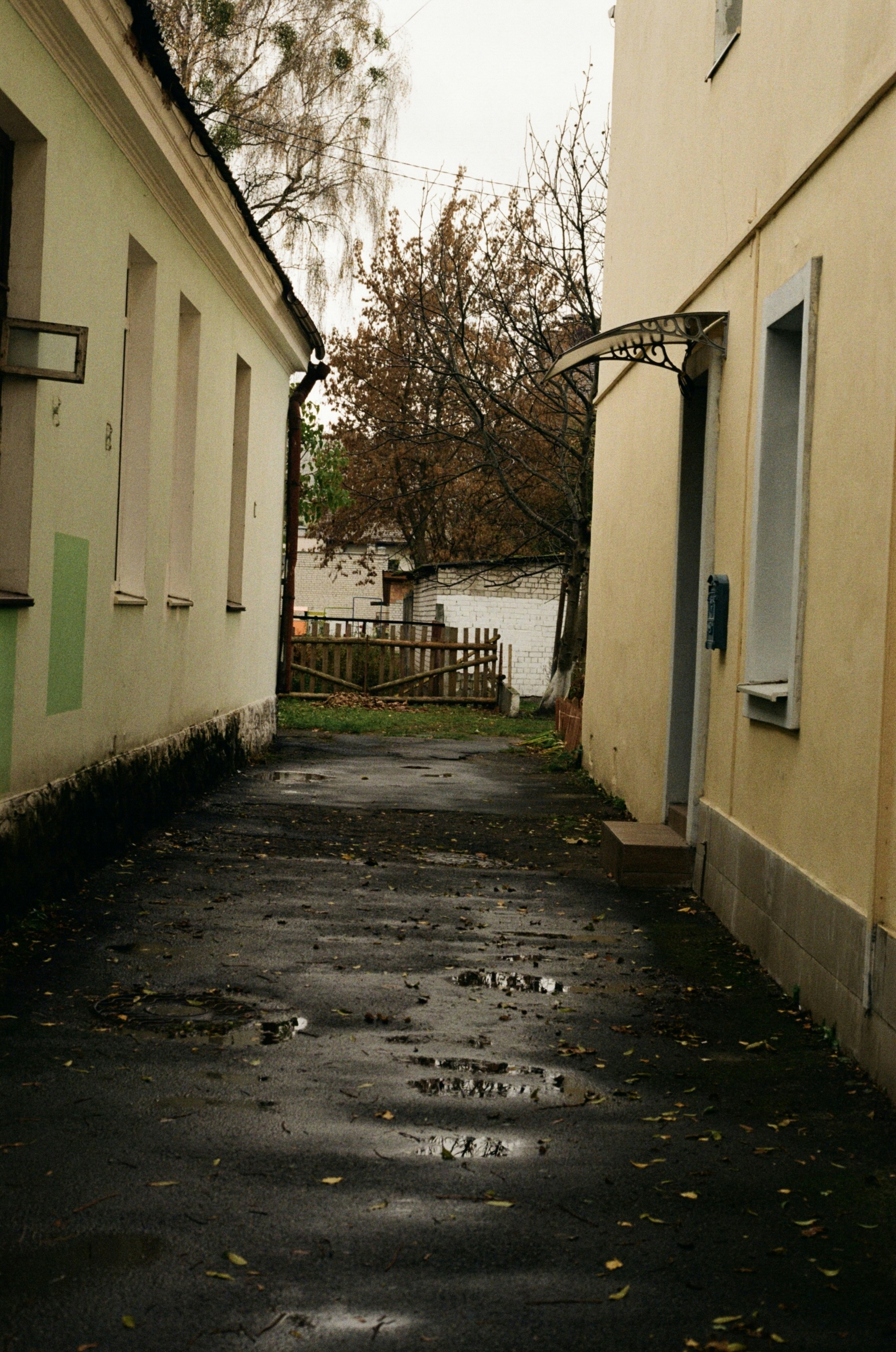 an alley way with a clock on the side of it