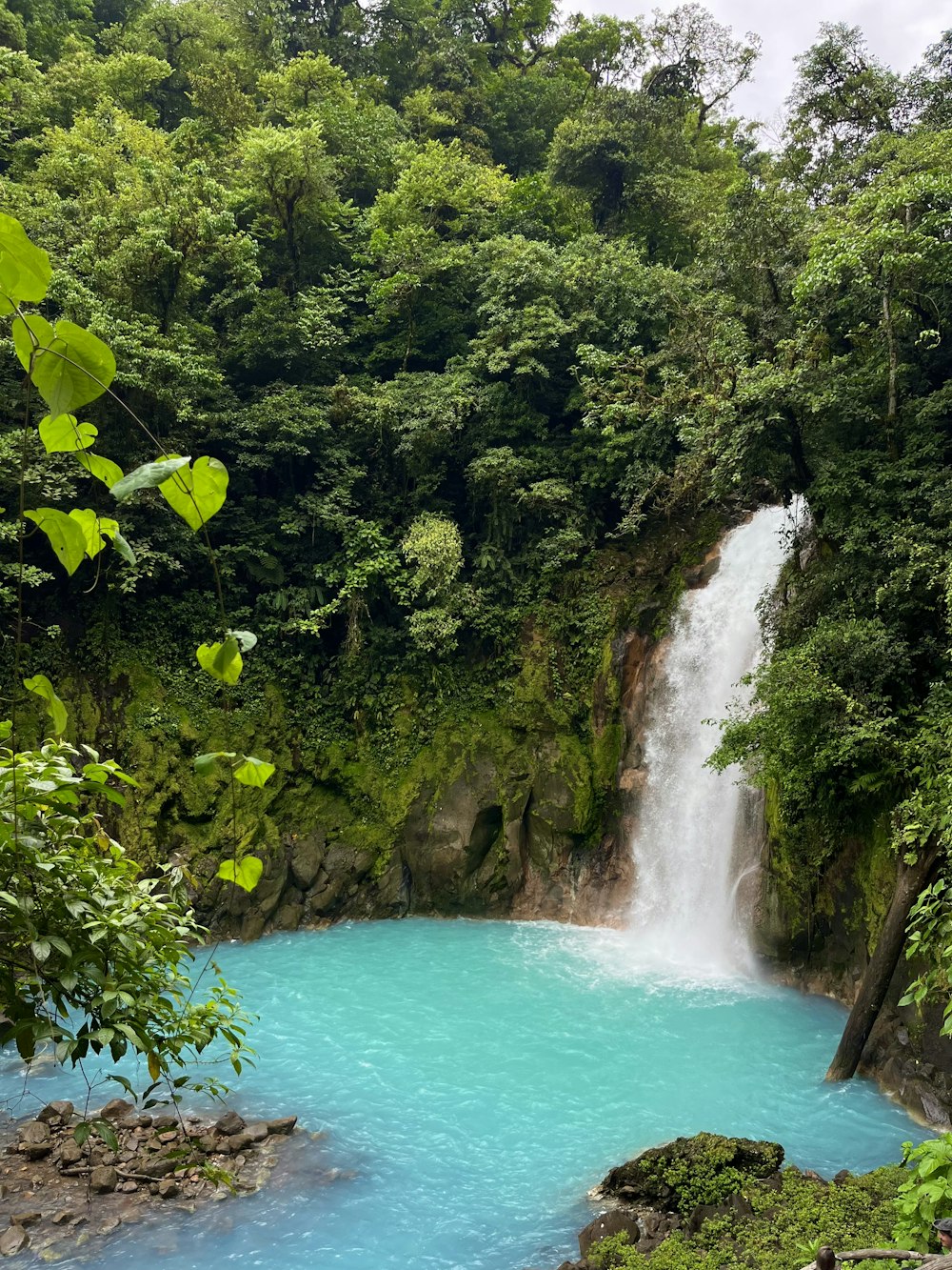 a waterfall in the middle of a blue river