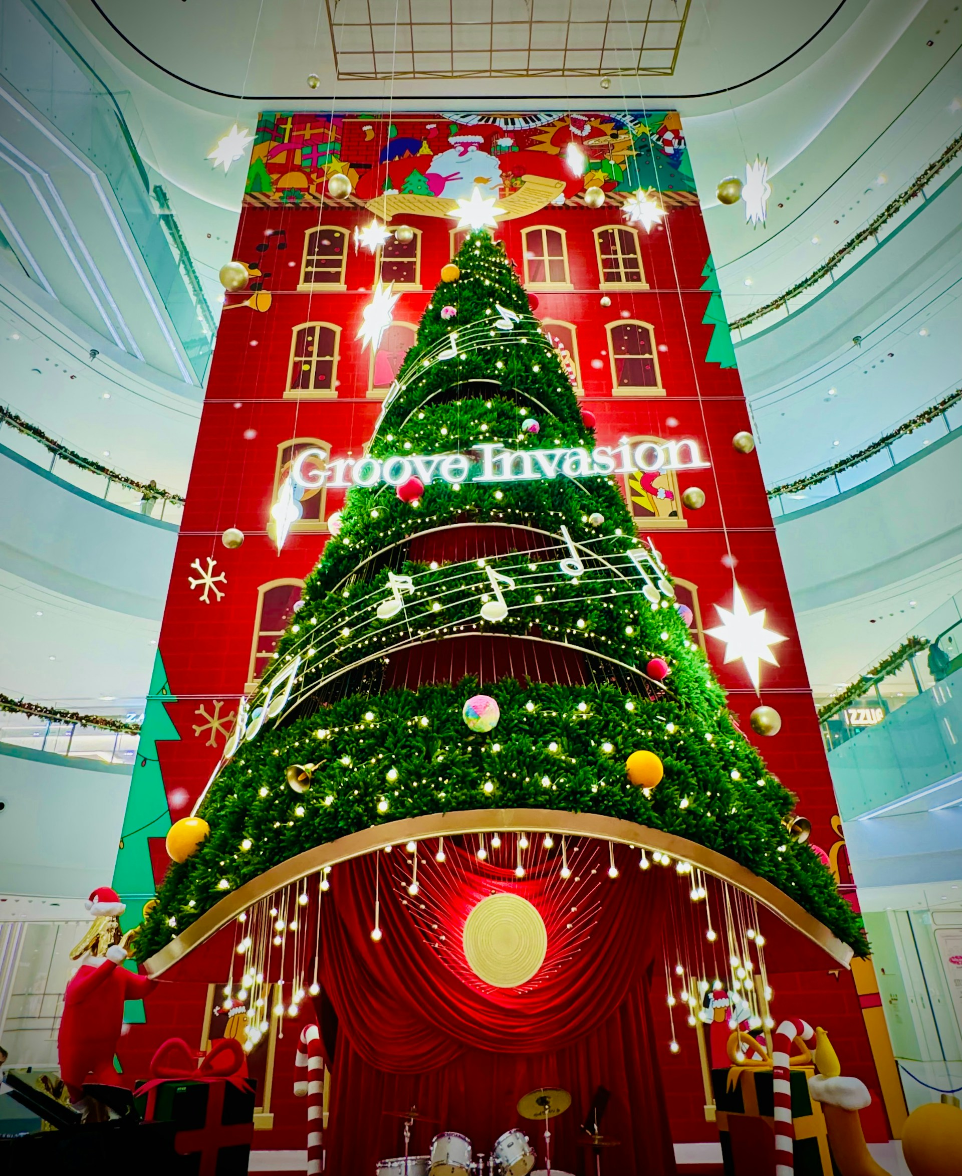 Community members gathered around a large Christmas tree inside the Kress building, sharing smiles and laughter as local musicians play holiday tunes.