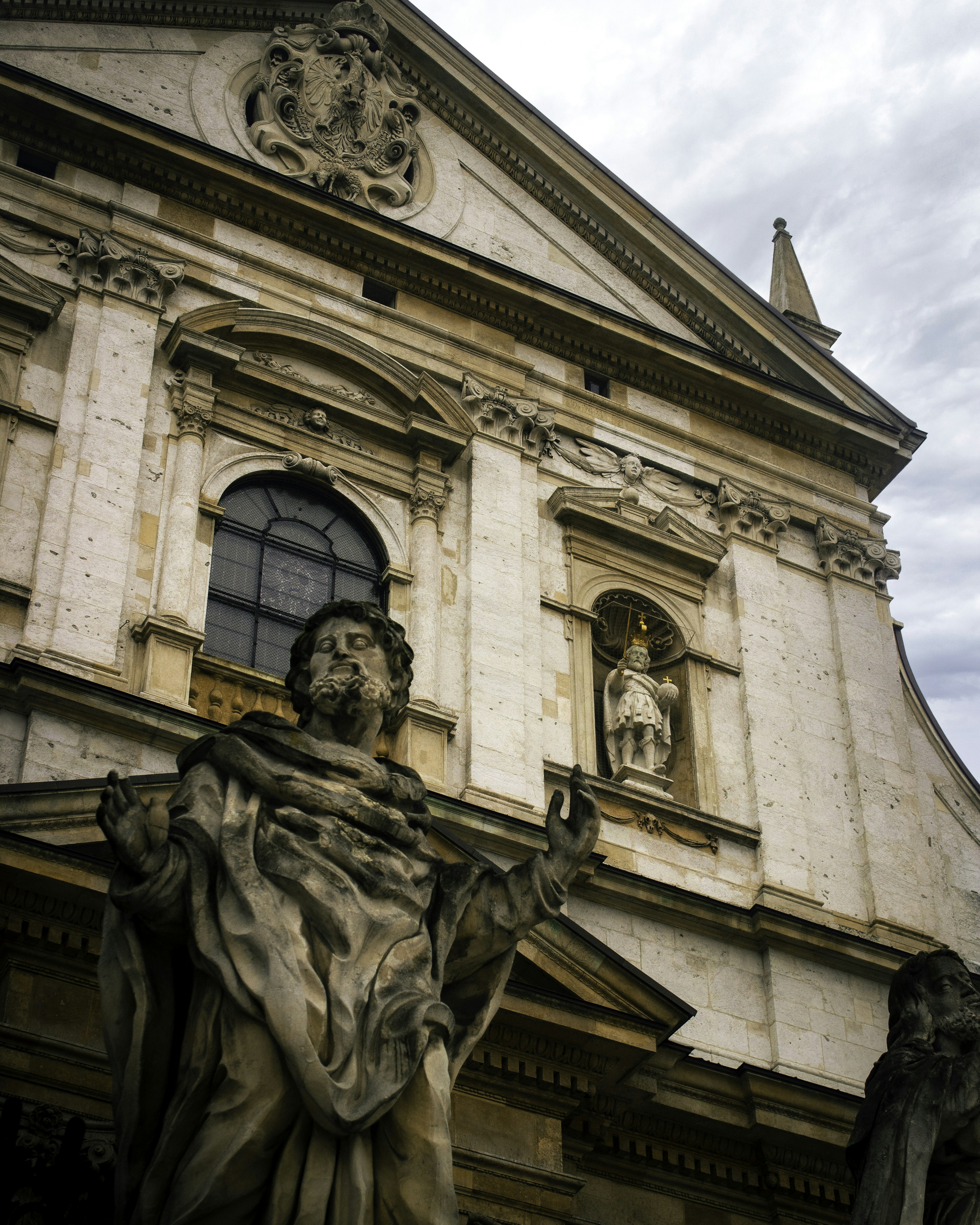 a statue of a man holding a book in front of a building