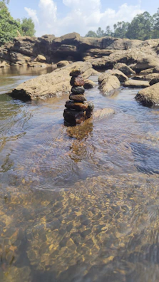 a stack of rocks sitting in the middle of a river