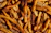 Close-up of golden crispy air fryer fries sprinkled with fresh herbs on a rustic wooden table.