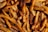 A close-up view of a pile of golden-brown French fries, sprinkled with coarse salt and tiny herbs. The fries are crispy in appearance, with visible texture and seasoning.