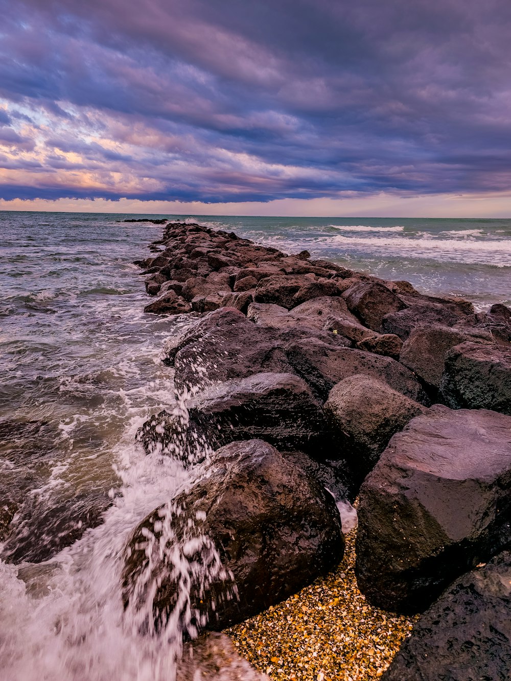 a rocky beach with waves crashing against the rocks