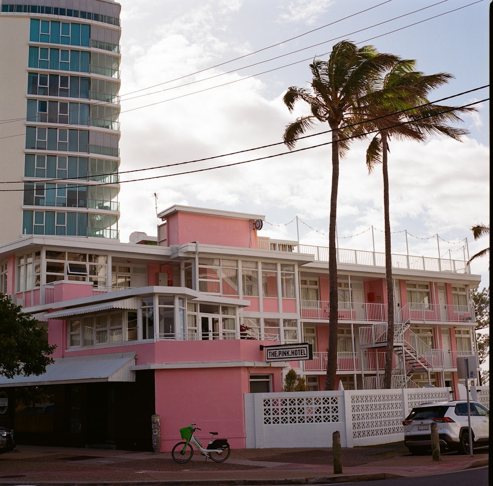 a pink and white building with a bicycle parked in front of it