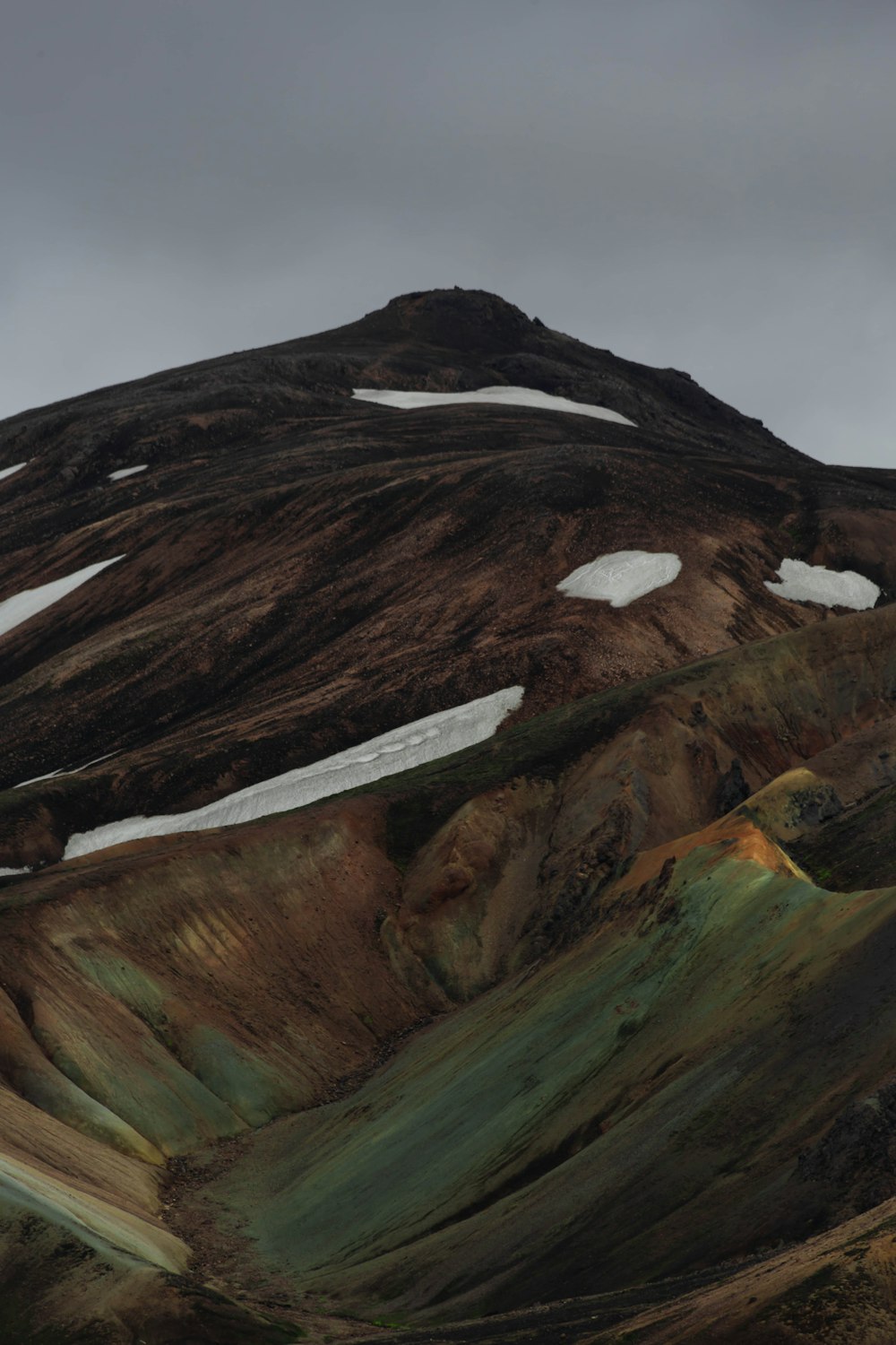 a mountain covered in green and brown hills