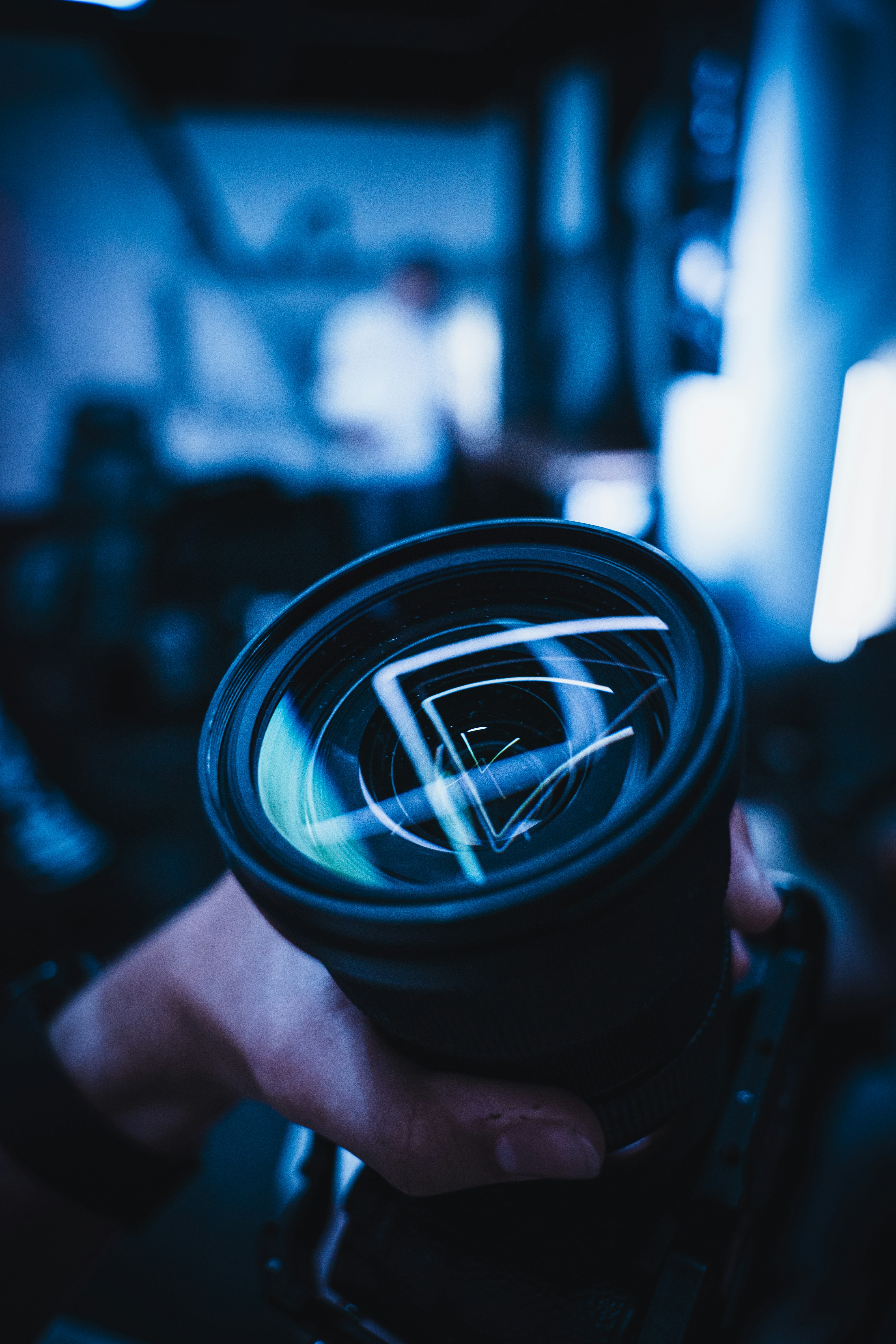 eine Person, die ein Kameraobjektiv in der Hand hält