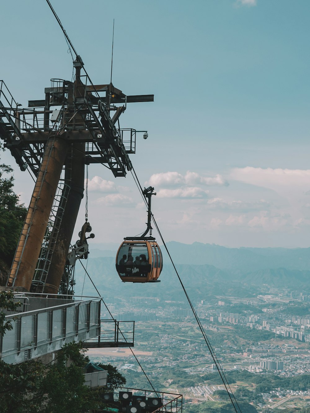 Un teleférico subiendo a una montaña con vistas a la ciudad