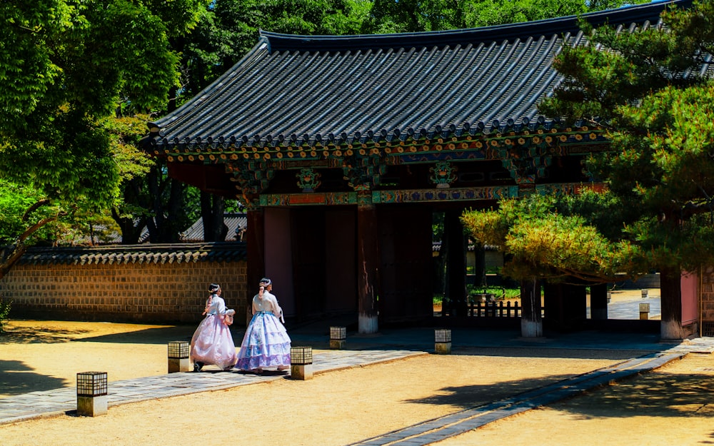 a couple of women walking down a street next to a building