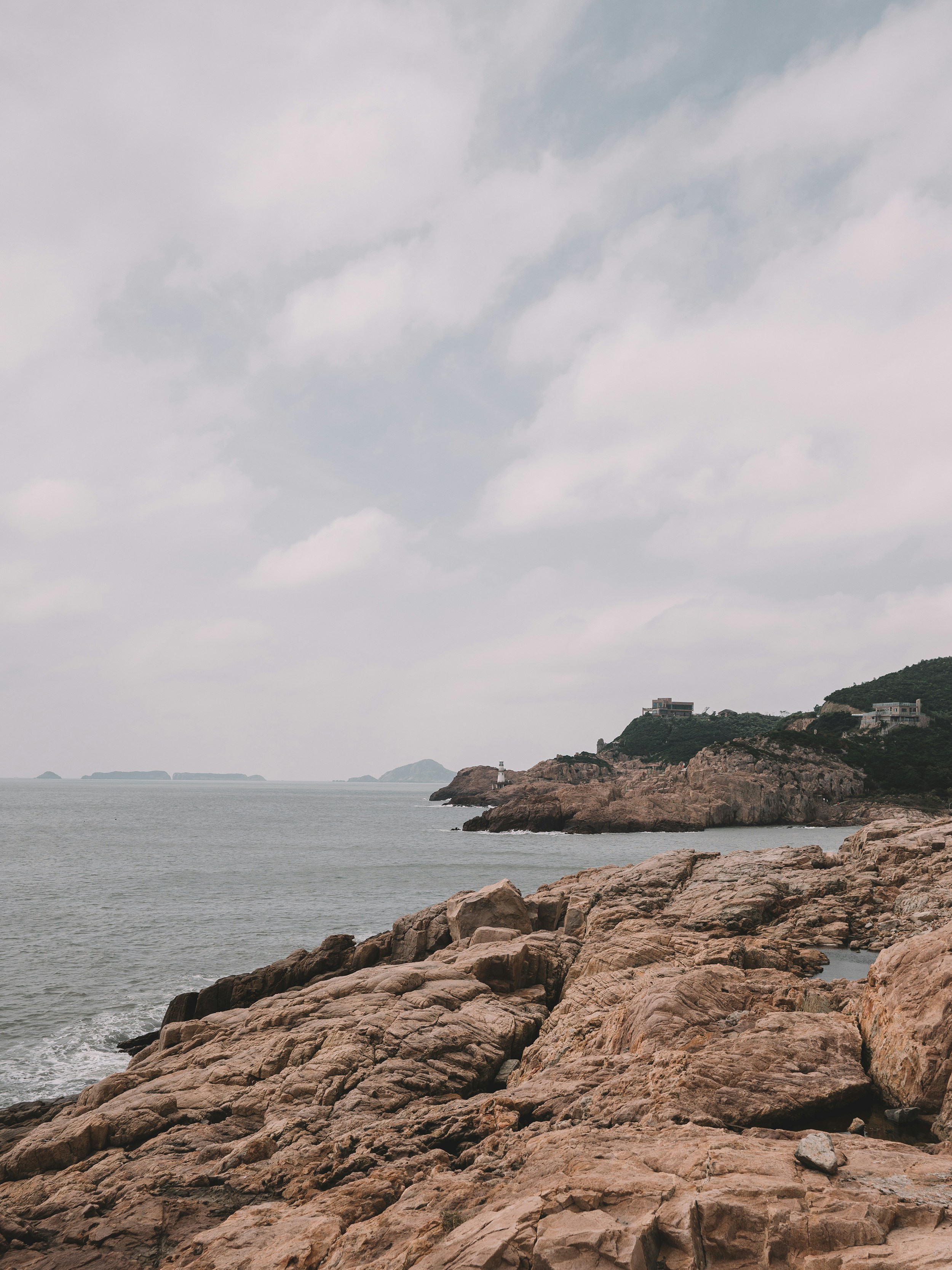 a person standing on a rocky beach next to the ocean