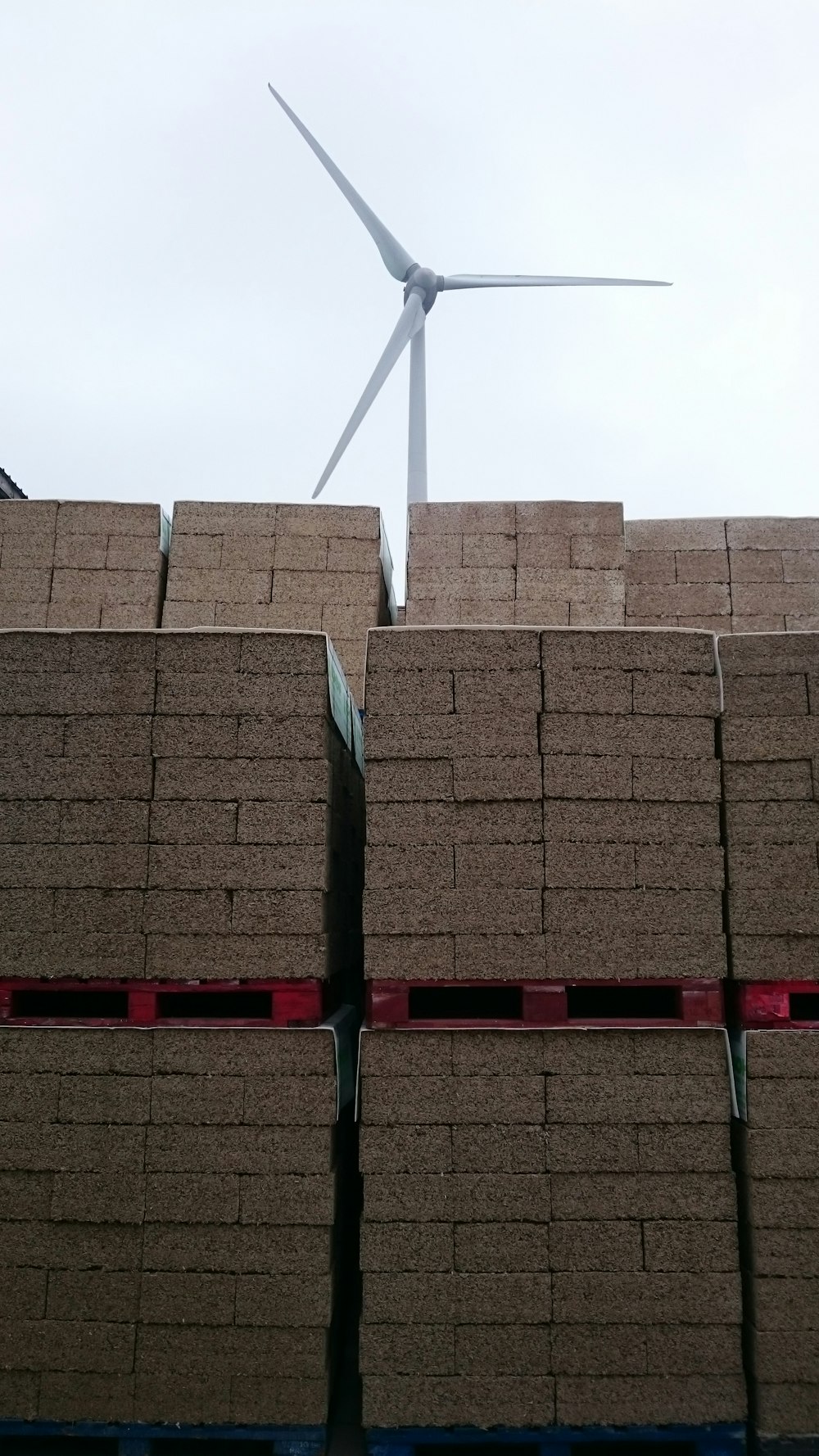 a stack of bricks with a wind turbine in the background