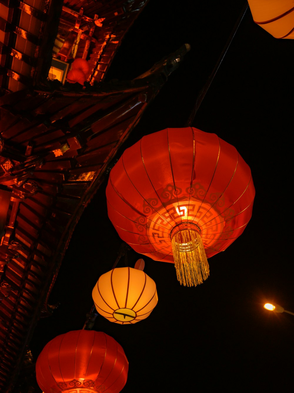 a group of red and yellow lanterns hanging from a ceiling