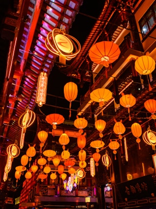 A vibrant street scene in Guangzhou at dusk, with glowing red lanterns and bustling markets reflecting the warmth of local life.