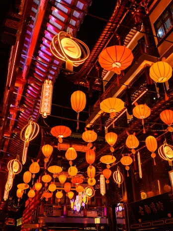 A vibrant street scene in Guangzhou at dusk, with glowing lanterns and bustling markets.