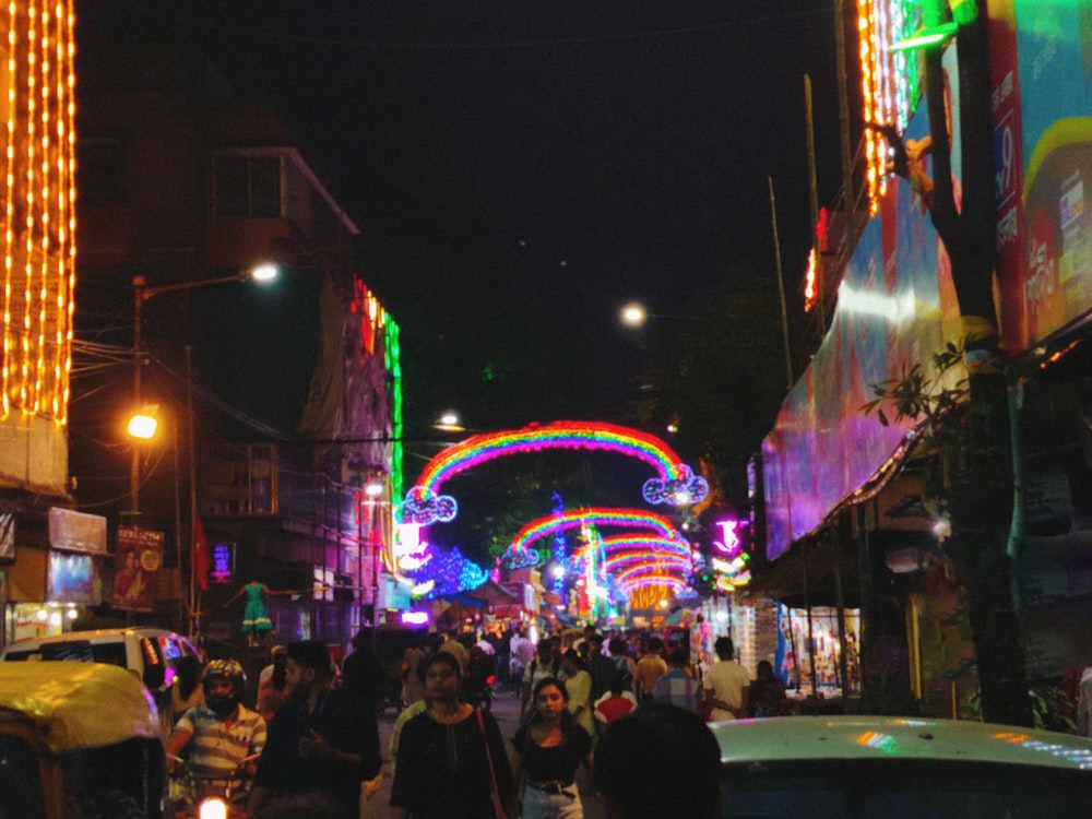 a group of people walking down a street at night