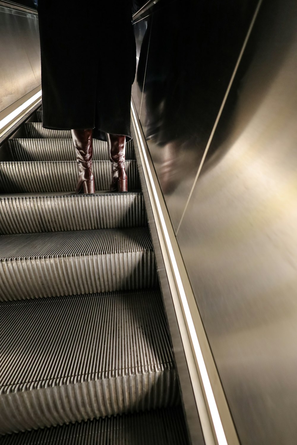 a person walking down an escalator with their feet up