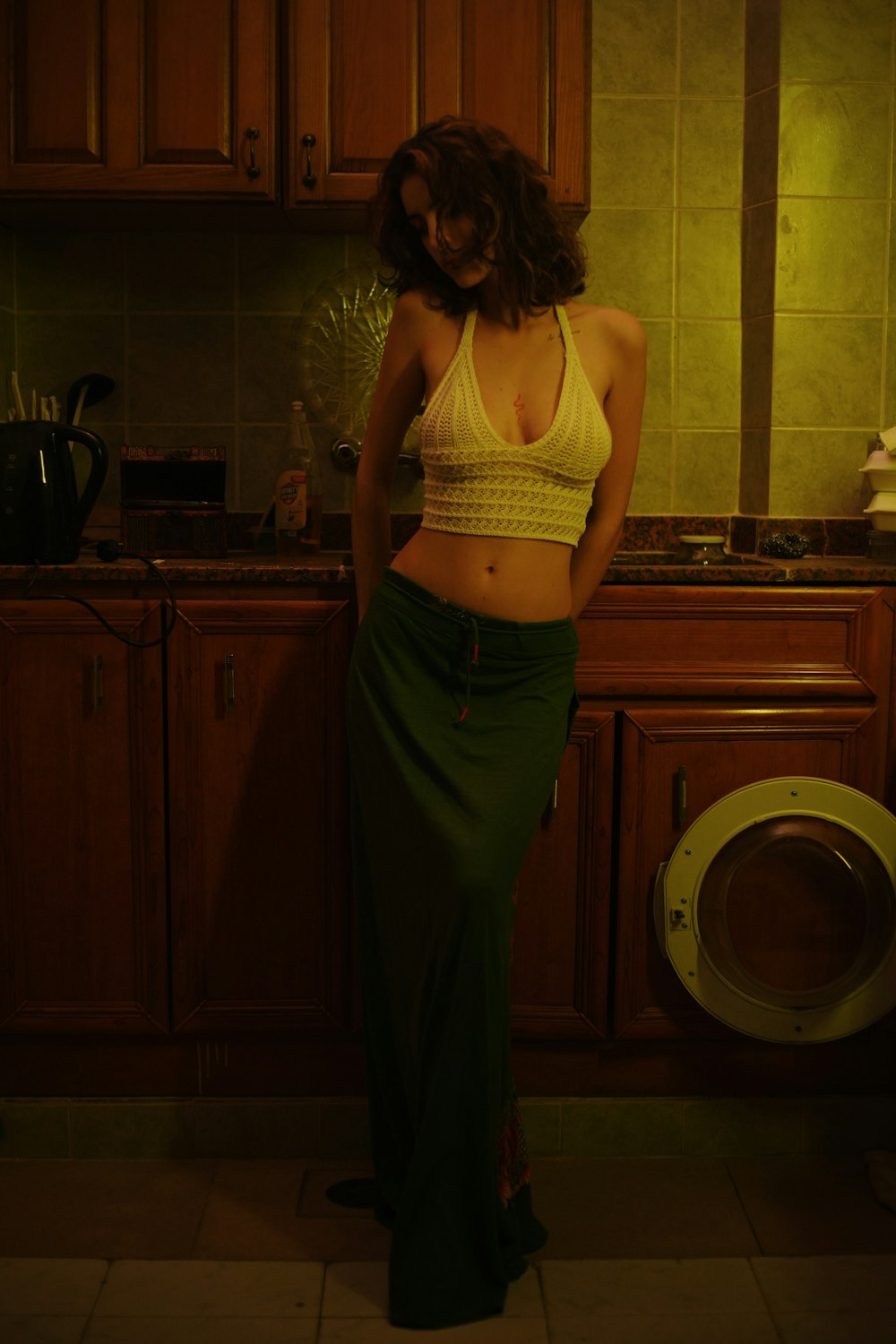 a woman standing in a kitchen next to a washer