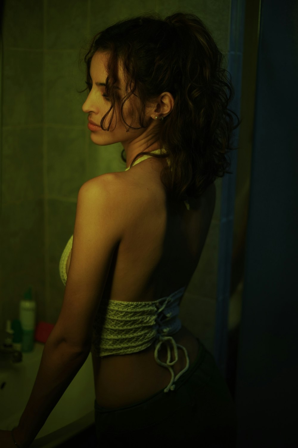 a woman standing in front of a mirror in a bathroom