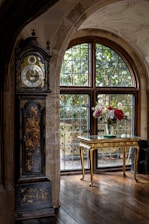 A beautifully restored grandfather clock standing tall in a cozy New York City living room.