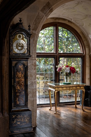 A beautifully restored grandfather clock standing tall in a cozy New York City living room.