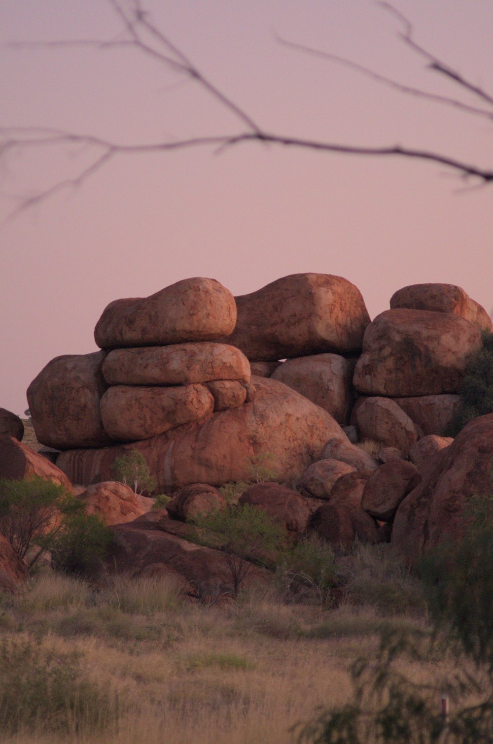 a pile of rocks sitting on top of a dry grass field