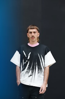 a man standing in front of a blue wall