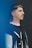 a man with a moustache standing in front of a blue wall