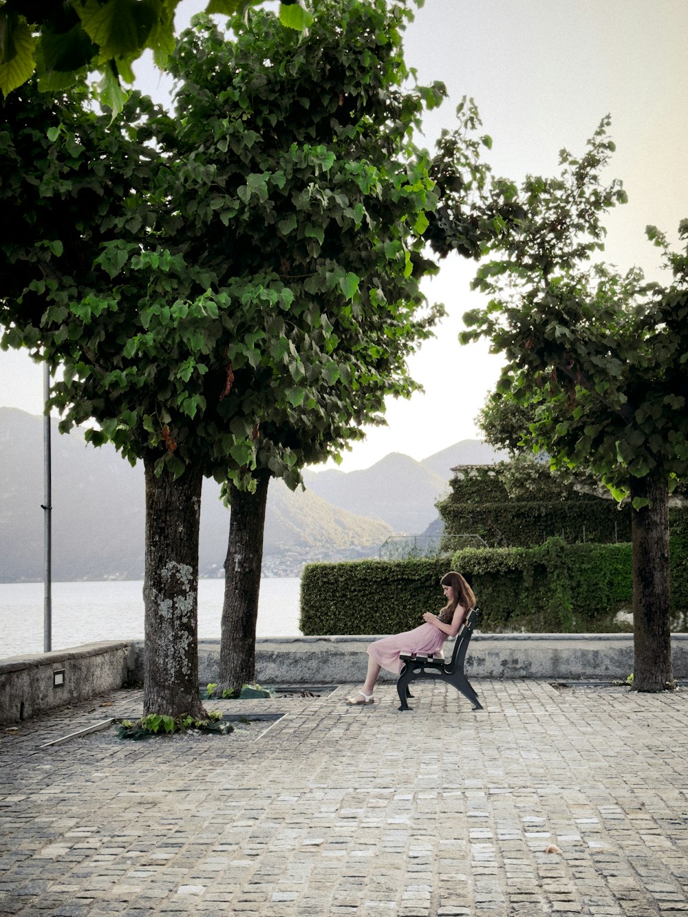 a woman sitting on a bench in a park