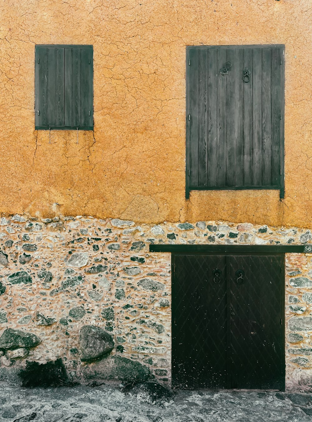 a stone building with two doors and a window