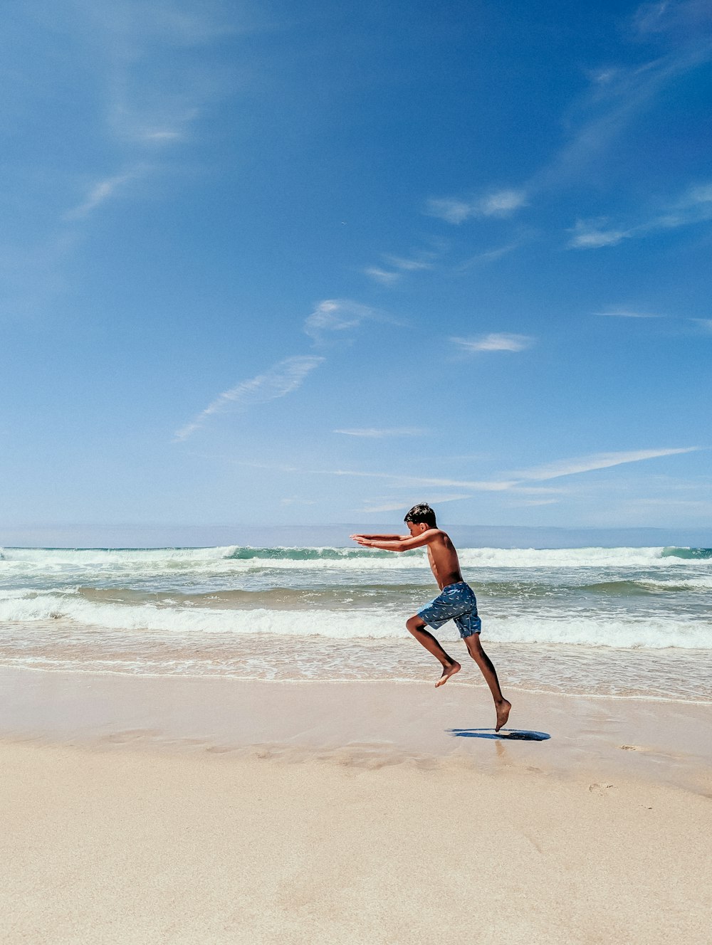 a man running on the beach with a frisbee