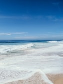A tranquil beach scene with gentle waves and soft sand.