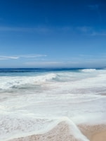 A tranquil beach scene with gentle waves and soft sand.