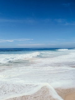 A tranquil beach scene with gentle waves and soft sand.